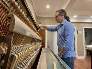 Tom Lepinski tuning an old upright piano in Edgewood, NM.